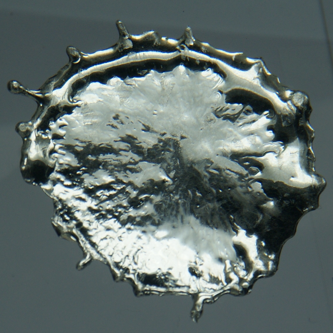 A blob of solid metallic tin with a bright crystalline surface